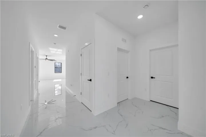 Corridor featuring recessed lighting and light marble finish floors