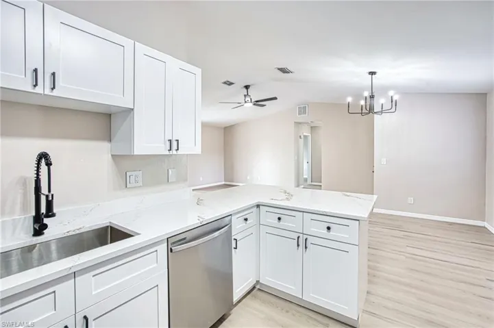 Kitchen with a ceiling fan, white cabinets, a peninsula, dishwasher, and light wood-style floors