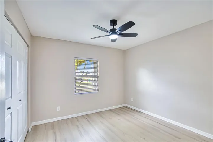Unfurnished bedroom featuring a closet, light wood-style flooring, and a ceiling fan