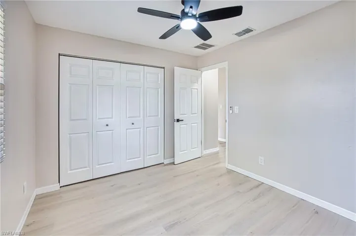 Unfurnished bedroom with light wood-type flooring, a ceiling fan, and a closet