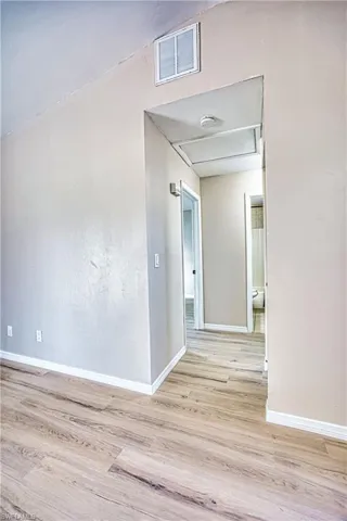 Hall with light wood-type flooring and baseboards