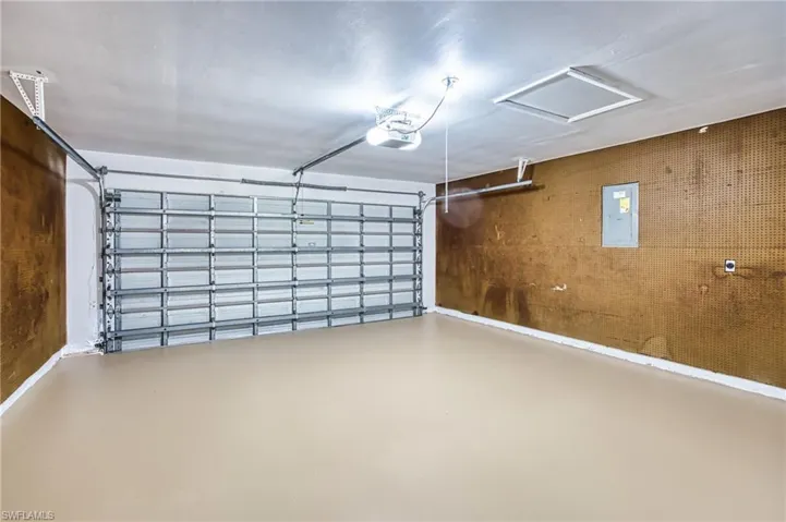 Garage featuring electric panel and a garage door opener