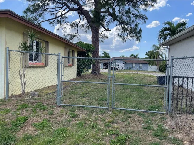 View of yard featuring fence and a gate