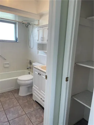 Full bathroom featuring tile patterned flooring, shower / bathtub combination, vanity, and toilet