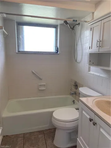 Full bath with tile patterned floors, toilet, shower / bathing tub combination, and vanity