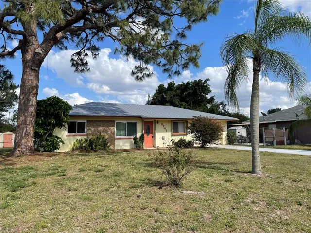 Single story home featuring a front yard, metal roof, and driveway