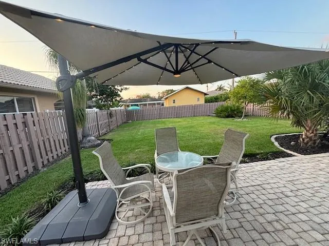 Patio terrace at dusk featuring a lawn