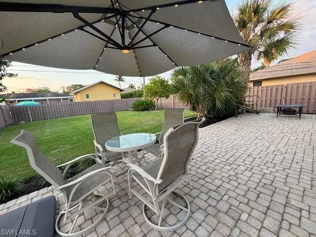 Patio terrace at dusk featuring a yard