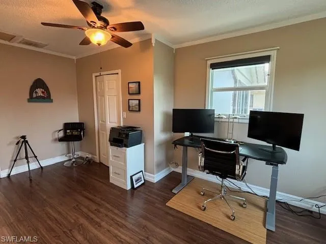 Office area with crown molding, a textured ceiling, ceiling fan, and dark hardwood / wood-style flooring