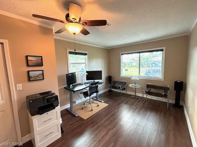 Home office featuring a textured ceiling, ceiling fan, dark hardwood / wood-style floors, and crown molding
