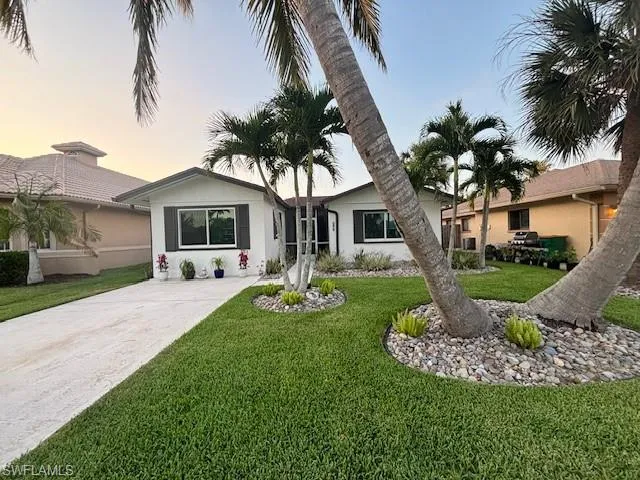 Ranch-style home featuring a lawn