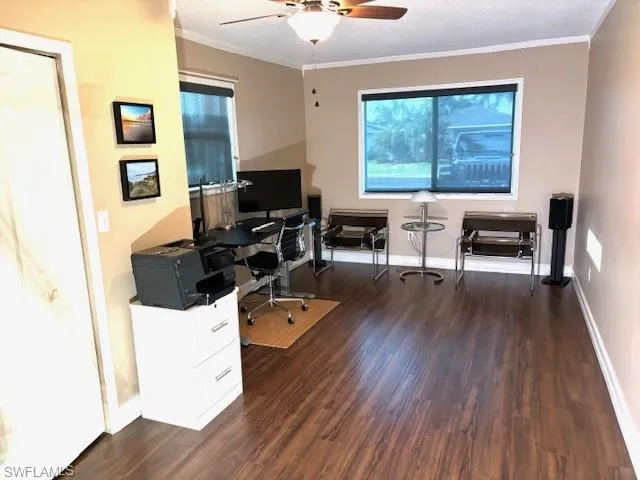 Office space featuring a textured ceiling, ceiling fan, dark hardwood / wood-style floors, and crown molding