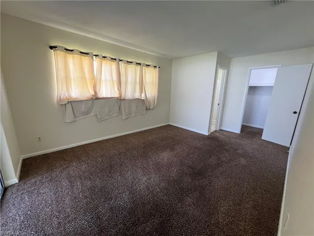Master bedroom with carpet flooring and a walk in closet