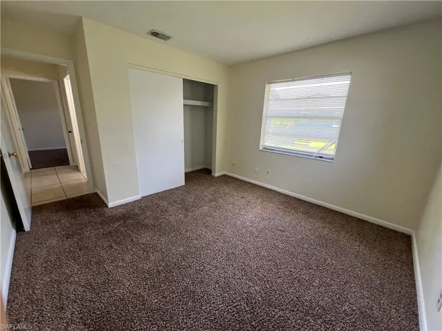 Guest bedroom featuring a closet and carpet