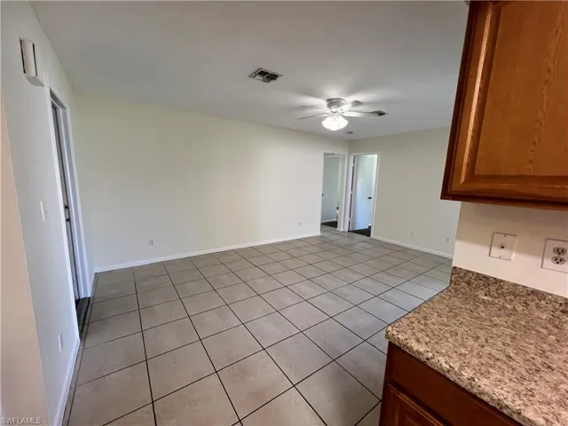 Family room with light tile patterned flooring and ceiling fan