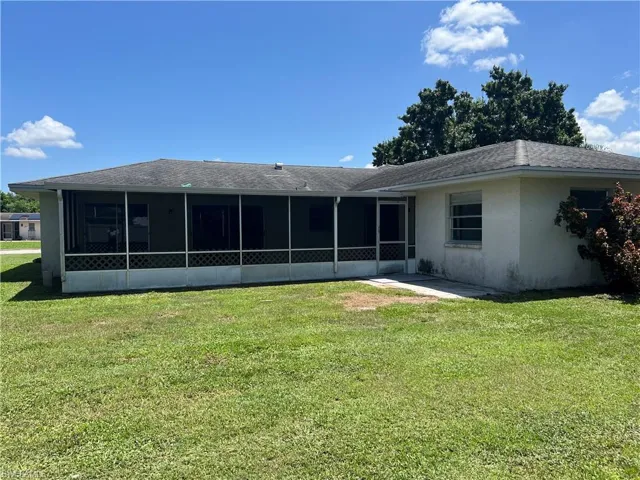 Back of house featuring a sunroom and a yard