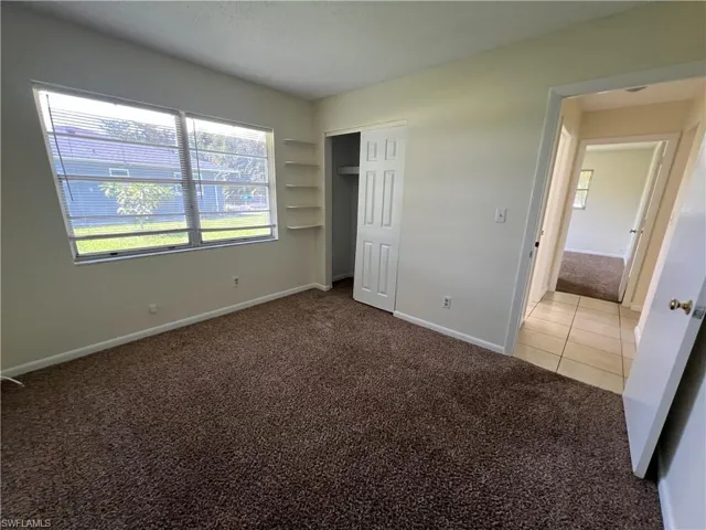 Guest bedroom with light carpet and a closet