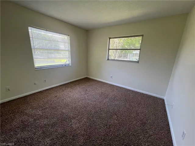 Guest bedroom with a textured ceiling and a healthy amount of sunlight