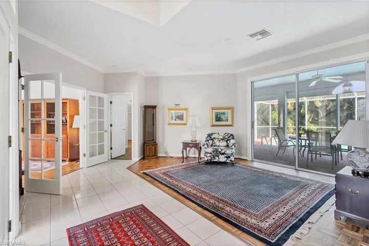 Living area with crown molding, french doors, light tile patterned floors, and ceiling fan