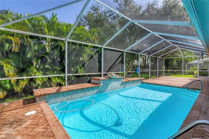 View of swimming pool featuring a lanai and a patio