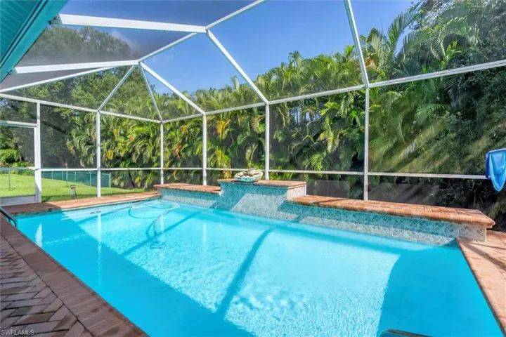 View of swimming pool featuring a lanai