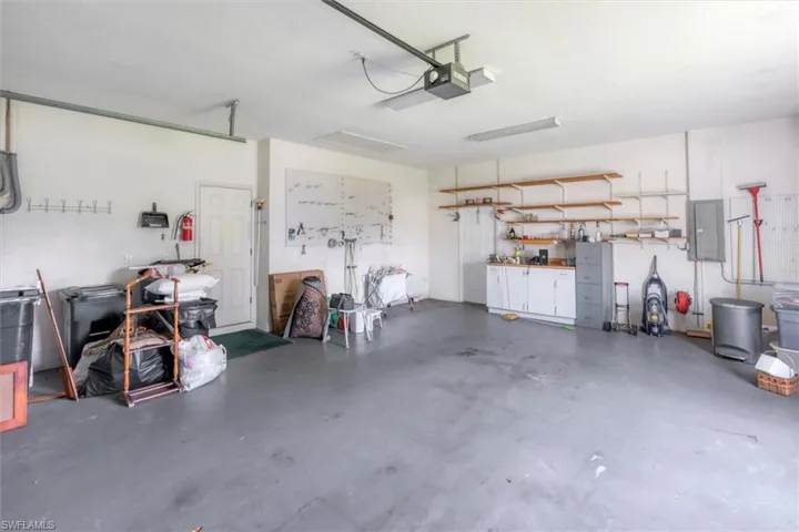 Garage featuring a garage door opener and electric panel