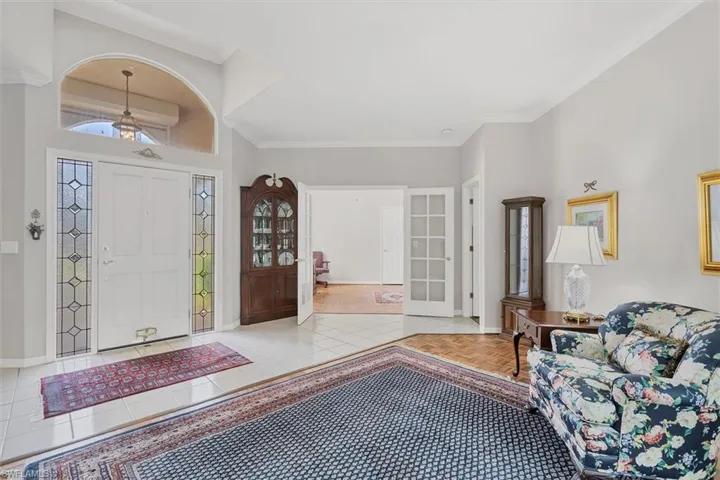 Foyer entrance featuring crown molding and light tile patterned floors