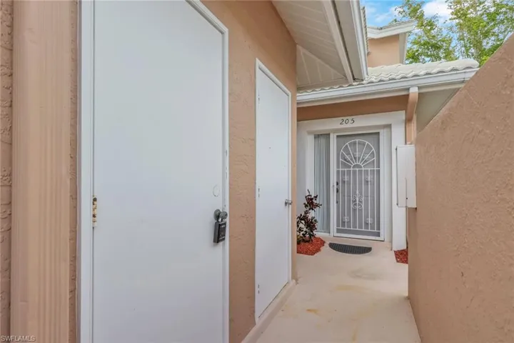 View of exterior entry featuring stucco siding and a tiled roof