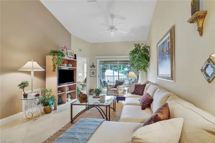 Tiled living room featuring ceiling fan and baseboards