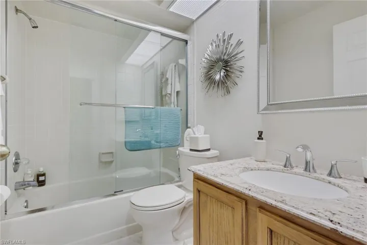 Full bathroom featuring vanity and shower / bath combination with glass door