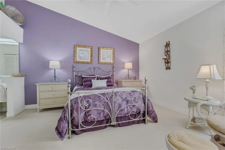 Bedroom with vaulted ceiling, carpet floors, and ceiling fan
