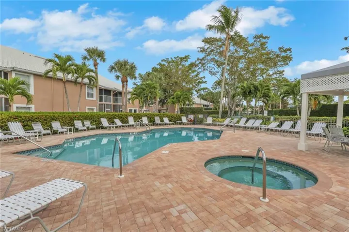 Community pool with a patio area and a community hot tub