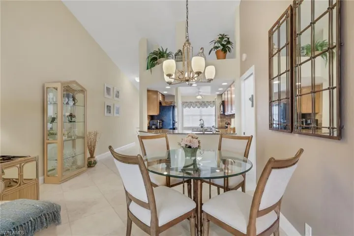 Dining space featuring a high ceiling, light tile patterned floors, and a chandelier