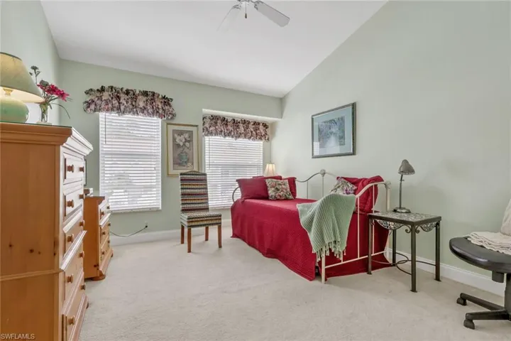 Bedroom with light colored carpet, a ceiling fan, and lofted ceiling