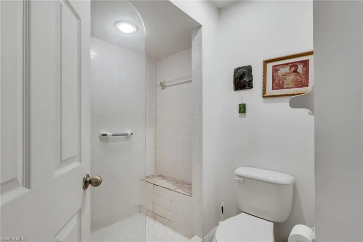 Full bathroom with tiled shower and toilet