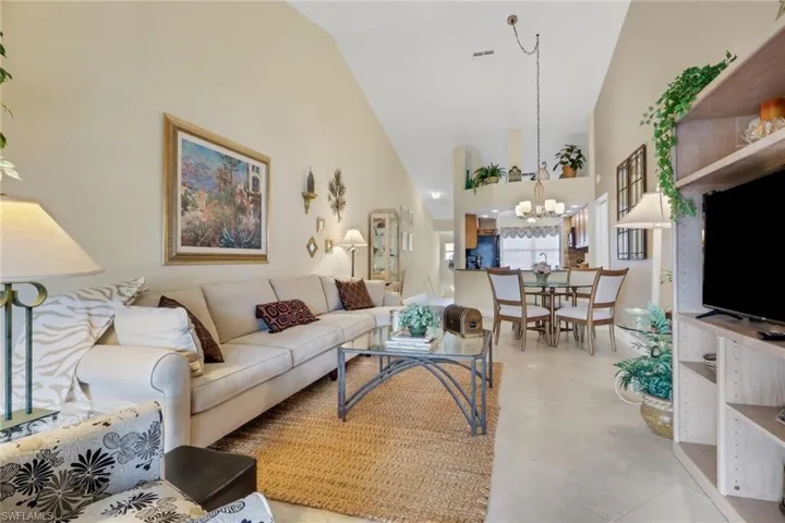 Living area featuring high vaulted ceiling and light tile patterned flooring