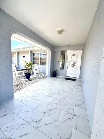 Doorway to property featuring stucco siding and a patio