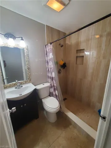 Full bathroom with vanity, a stall shower, and light tile patterned flooring