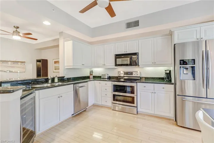 Kitchen featuring stainless steel appliances, white cabinets, recessed lighting, and crown molding