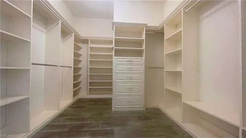 Spacious 1 of 2 Primary Bedroom Walk-In Closets with Custom Shelving