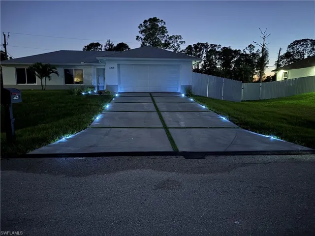 View of front facade featuring a lawn and a garage