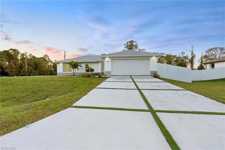 View of front of home featuring a lawn and a garage