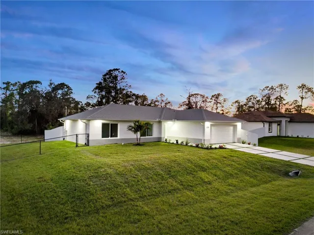 Single story home featuring a garage and a lawn
