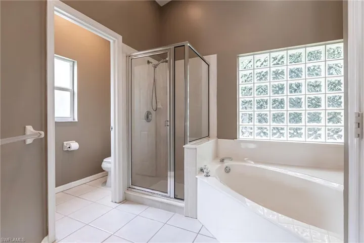 Bathroom featuring toilet, tile patterned flooring, and independent shower and bath