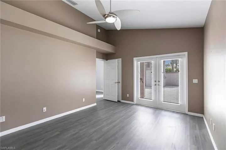 Unfurnished room with high vaulted ceiling, french doors, hardwood / wood-style floors, and ceiling fan