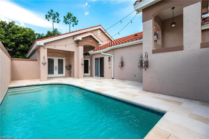 View of swimming pool with french doors and a patio area