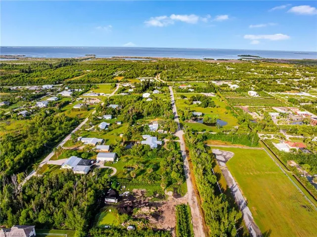 Aerial view of property and surrounding area featuring a large body of water and nearby suburban area