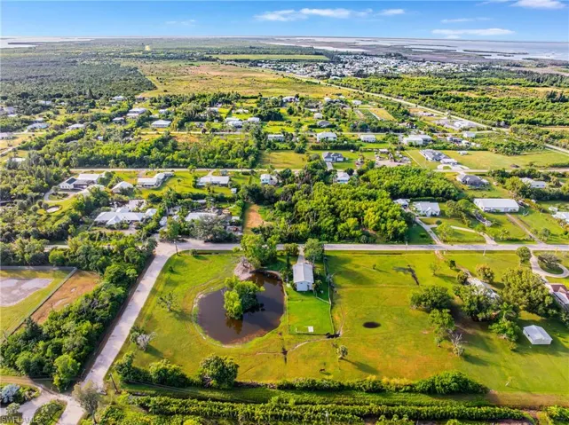 Aerial overview of property's location featuring a tree filled landscape and a large body of water