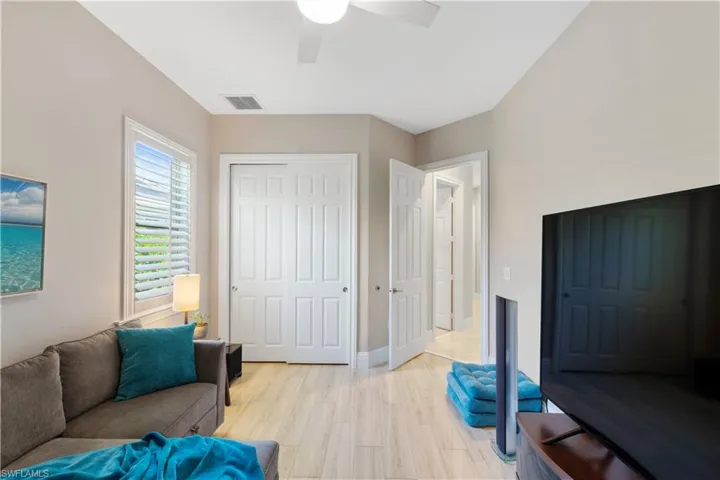 Bedroom / TV room with light ceramic tile flooring and ceiling fan