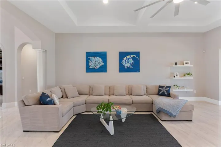 Bright open great room featuring tray ceiling and contemporary ceiling fan